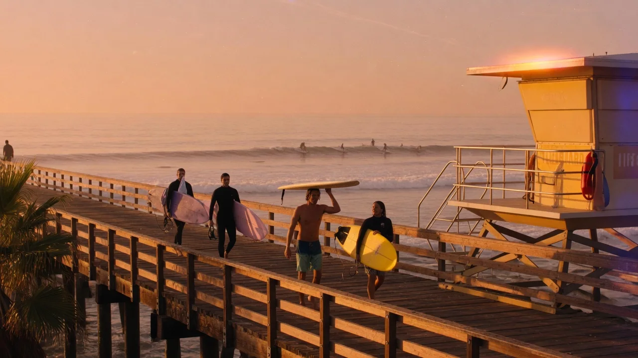 Golden-hour Southern California beach pier with surfers